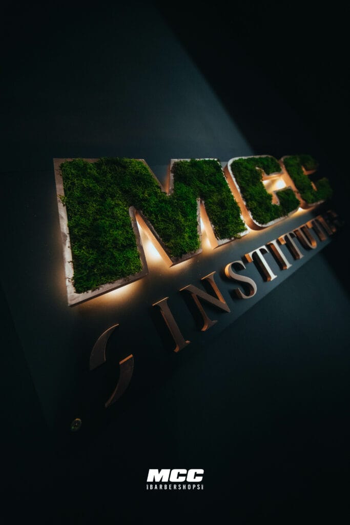 Logo MCC Institute en mur végétal dans un salon MCC Barbershops